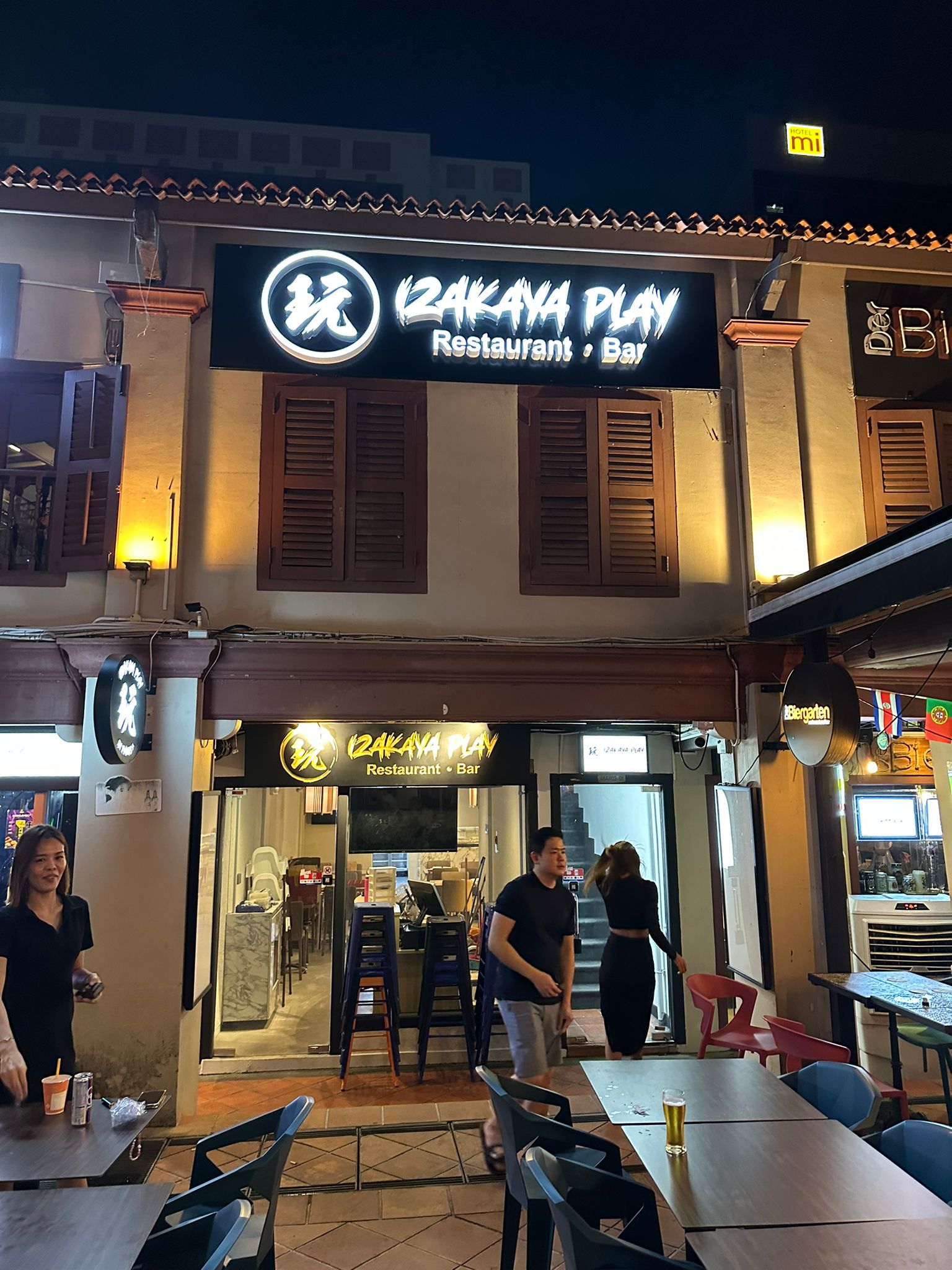 Izakaya Play main entrance at night with illuminated signage